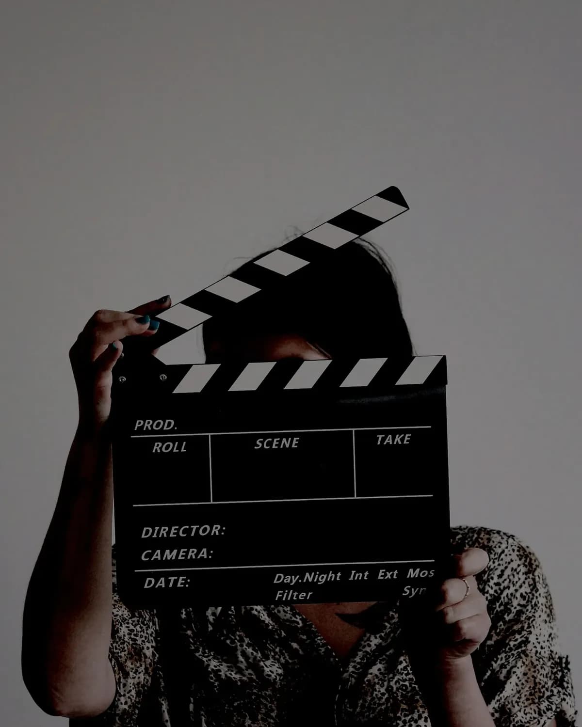 A clapperboard held up on set, in black and white